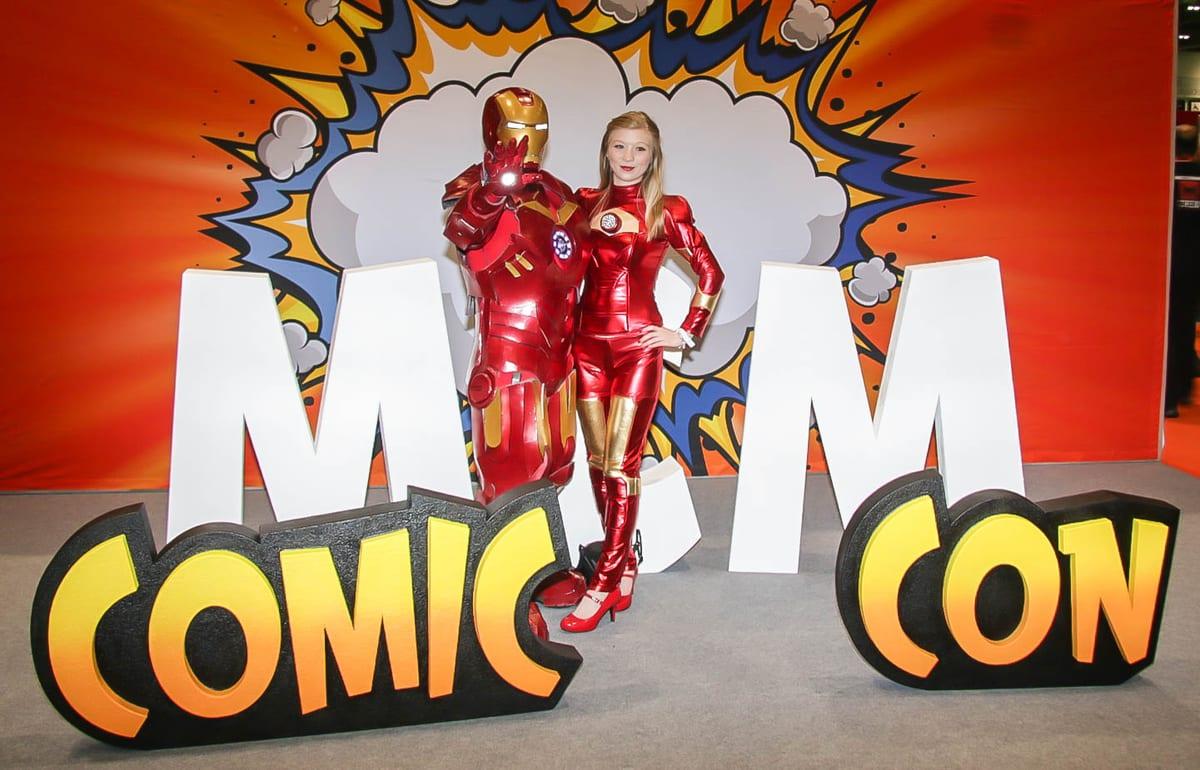 Iron Man cosplayers in red and gold armor at a comic convention