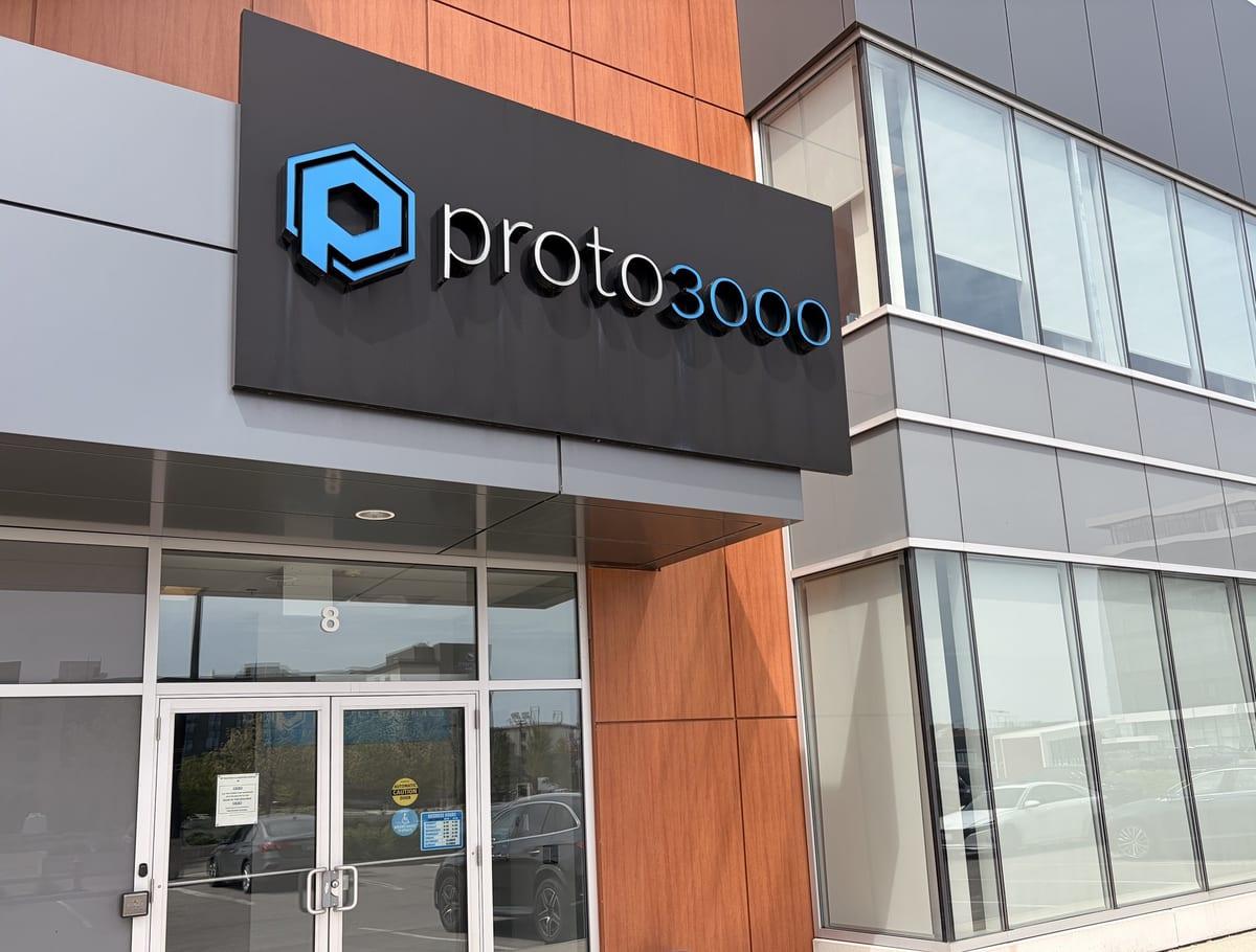 Exterior entrance of a commercial 3D printing service bureau with signage above glass doors