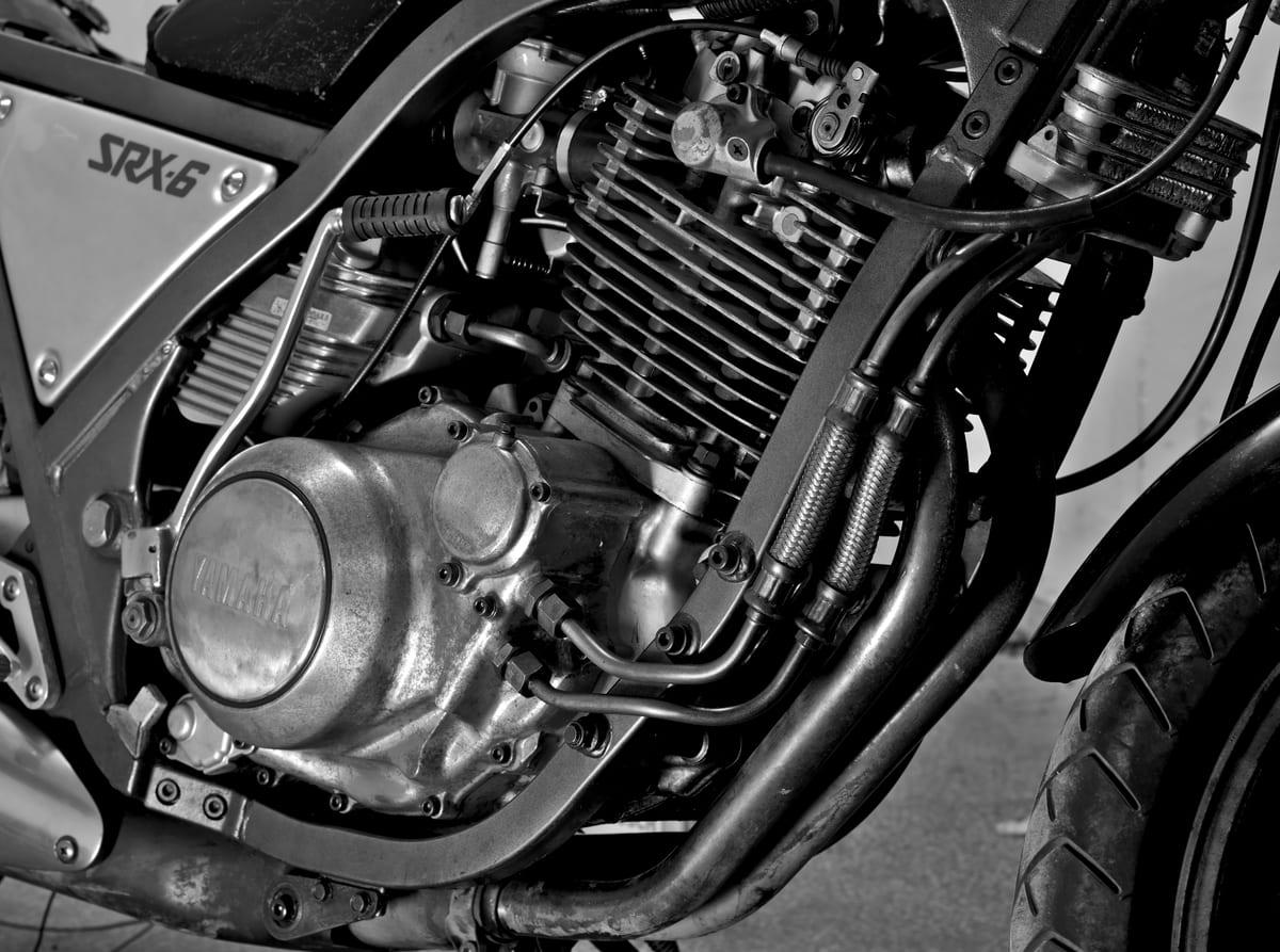 Detail view of a large air-cooled single-cylinder motorcycle engine showing cooling fins and cases
