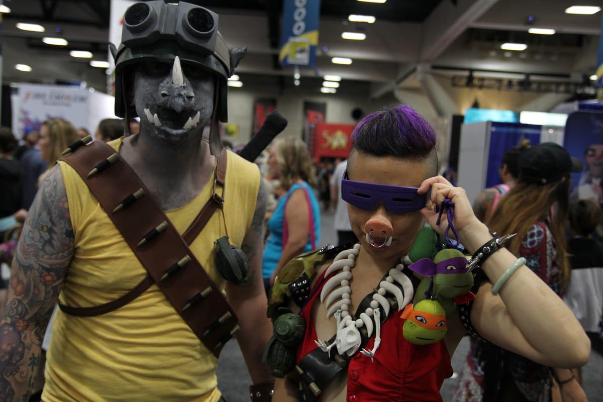 Cosplayers in detailed sculpted character costumes at a comic convention