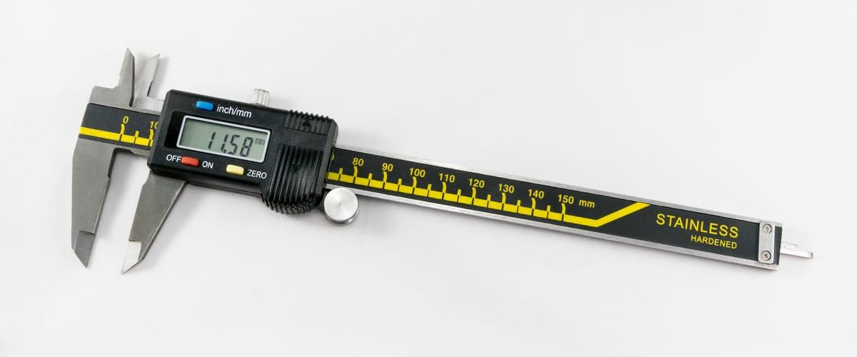 A digital caliper displaying a measurement, lying on a flat surface