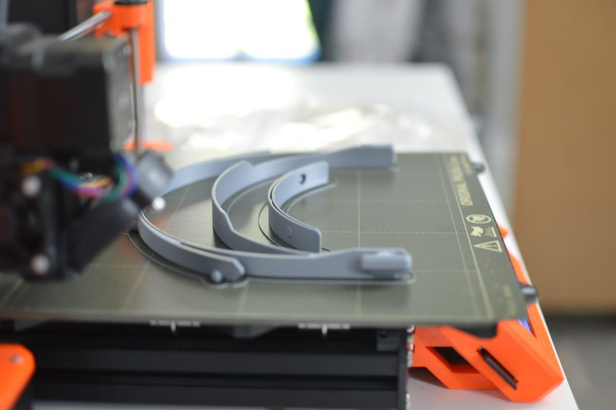 Three identical printed parts sitting together on a 3D printer build plate