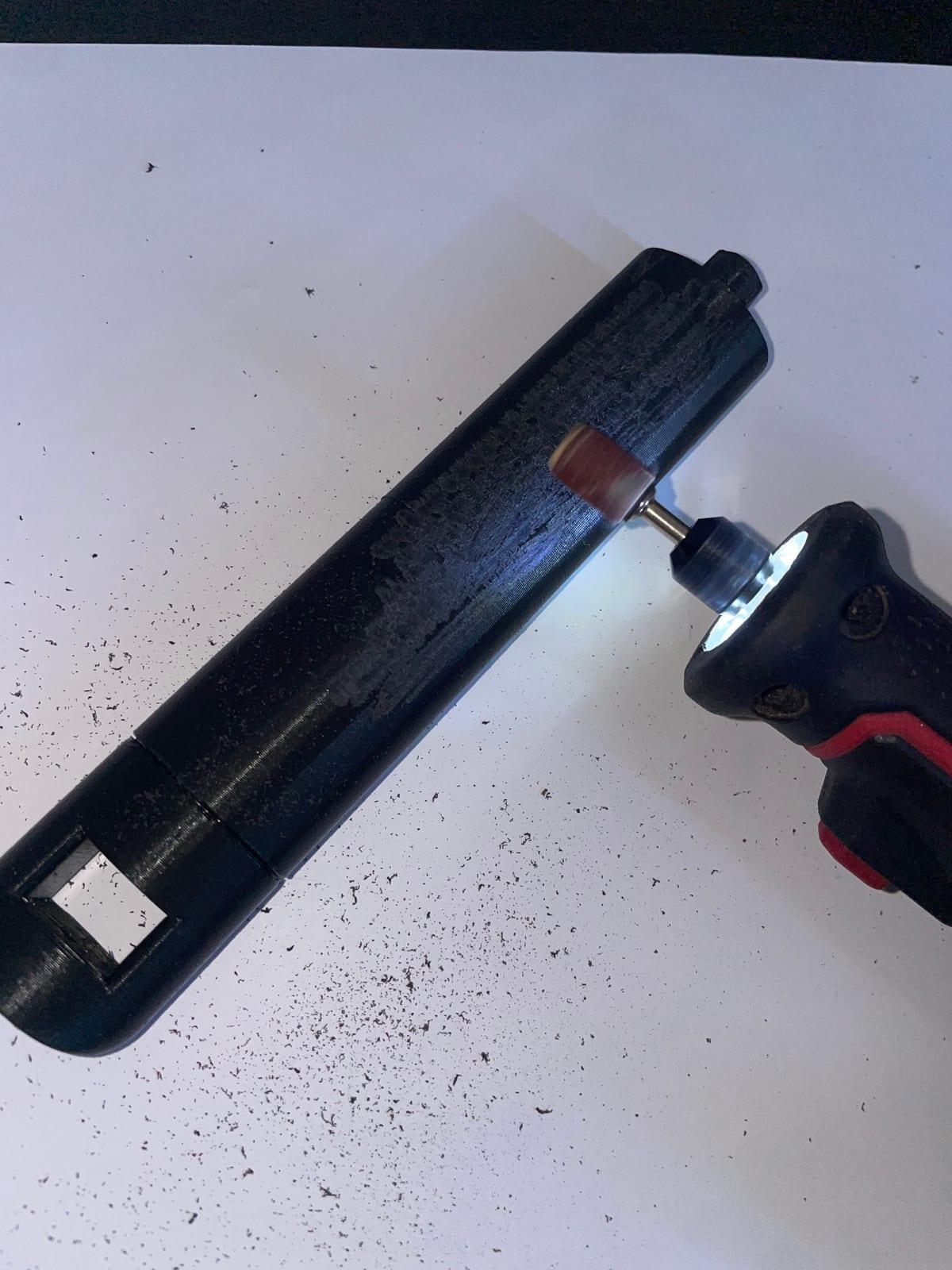 A 3D printed part being sanded with a handheld rotary tool