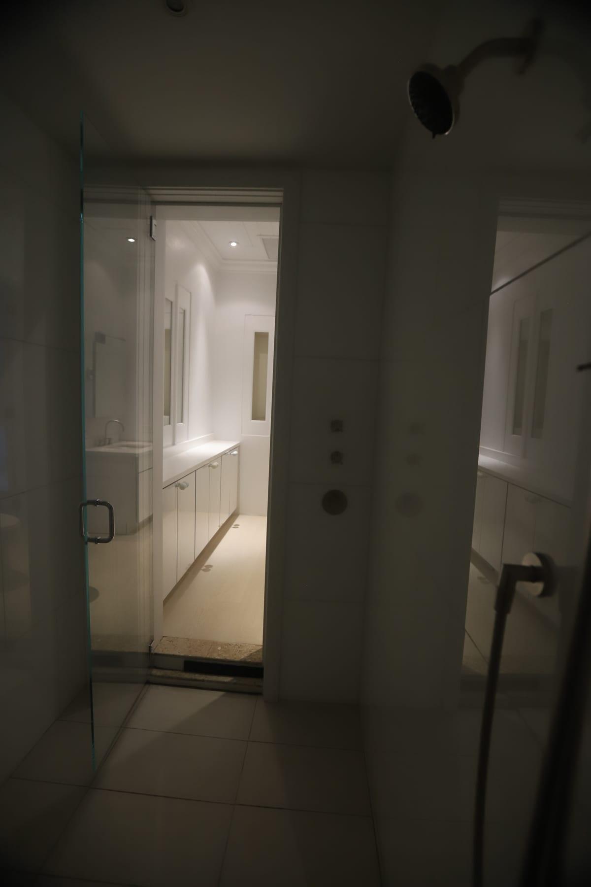 A modern tiled shower with frameless glass doors, seen from inside the shower area