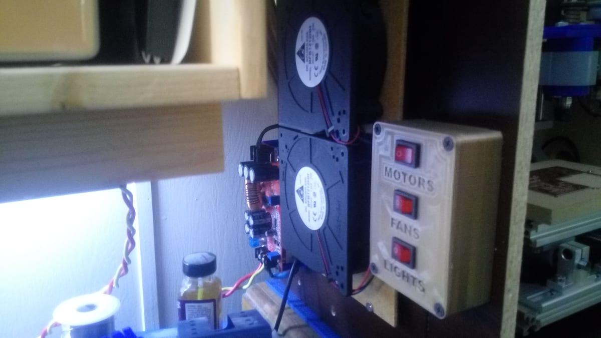 A 3D printed control box with three labelled rocker switches mounted to a machine frame